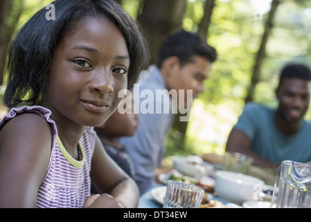 Une jeune fille et adultes assis à la table Banque D'Images