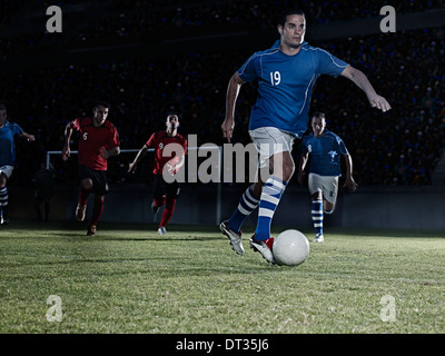 Les joueurs de soccer ball chasse sur terrain Banque D'Images