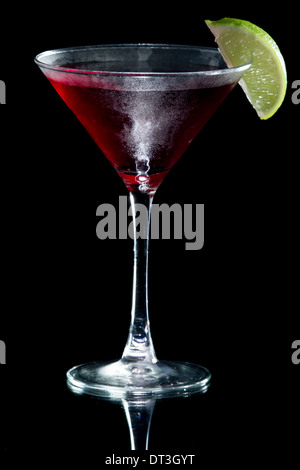 Martini servi avec un tilleul isolé sur un fond noir Banque D'Images