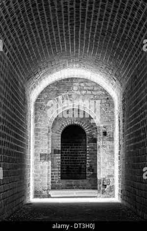 Bordée de briques tunnel menant à une entrée dans une guerre civile fort. Converties en noir et blanc. Banque D'Images