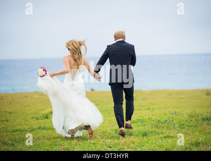 Couple de mariage, Happy romantic couple amoureux running through field Banque D'Images