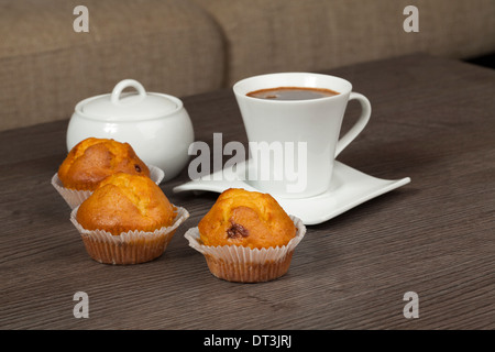 Tasses de café et muffins closeup on wooden table Banque D'Images