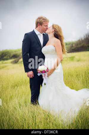 Couple de mariage, Happy Bride and Groom in Love Kissing in Field Banque D'Images