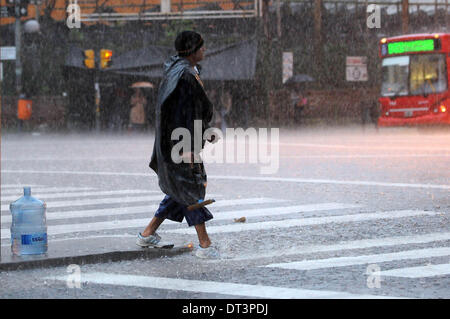 Buenos Aires, Argentine. 7 Février, 2014. Un homme marche sous la pluie dans une rue de Buenos Aires, capitale de l'Argentine, le 7 février, 2014. Averses depuis le vendredi matin à Buenos Aires ont inondé les domaines de la Plata et d'Ensenada les municipalités et a nécessité l'évacuation de personnes à Berisso township, selon la presse locale. Credit : Leonardo Zavattaro/TELAM/Xinhua/Alamy Live News Banque D'Images