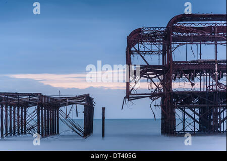 Brighton, Sussex, UK. 7 février 2014. Une autre tempête est prévue et les amateurs de la célèbre Brighton West Pier rassembler sur la plage en ce qui pourrait être un dernier adieu à la structure de la rouille. Une grande partie de il s'est effondré mercredi, personne ne sait combien de temps le reste peut contenir jusqu'. Crédit photo : Julia Claxton/Alamy Live News Banque D'Images