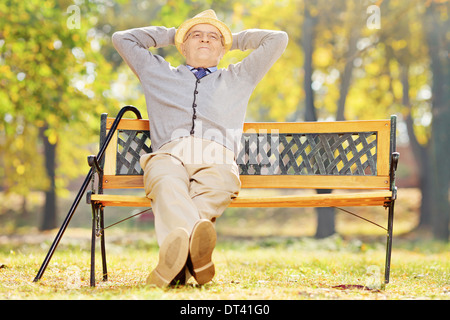 La haute atmosphère gentleman assis sur un banc dans un parc sur une journée ensoleillée Banque D'Images