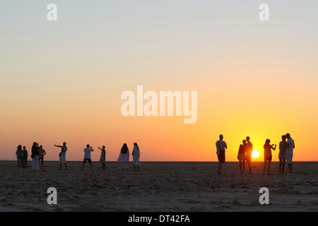 Les touristes à regarder et photographier le lever du soleil à chott El Jerid, grand lac salé dans le sud de la Tunisie. Banque D'Images