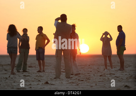 Les touristes à regarder et photographier le lever du soleil à chott El Jerid, grand lac salé dans le sud de la Tunisie. Banque D'Images