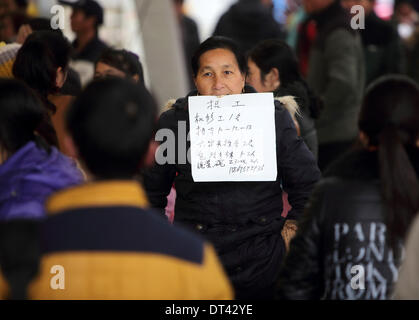 Shanghai, Chine, la Province de Zhejiang. Feb 8, 2014. Avis d'embauche une femme en bouche à un marché du travail de Zhuji City, Zhejiang Province de Chine orientale, le 8 février 2014. Que la Nouvelle Année lunaire chinoise à la fin des vacances, beaucoup de gens ont commencé à chercher d'emploi récemment. © Guo Bin/Xinhua/Alamy Live News Banque D'Images