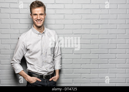 Portrait smiling Casual Male en brique à la caméra de studio Banque D'Images