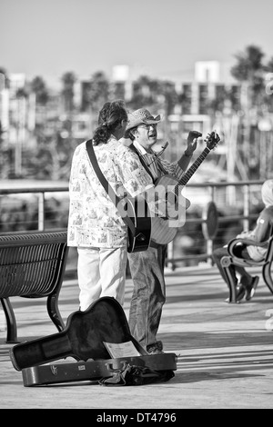 Photo en noir et blanc de deux Street Performers (Buskers) jouant devant la foule sur Redondo Pier, Los Angeles, Californie, États-Unis Banque D'Images