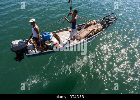 Bateaux de pêche lancé et récupéré par la grue du quai de pêche à La Libertad, une ville portuaire sur la côte d'El Salvador Banque D'Images