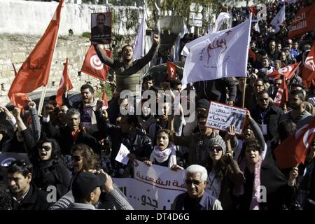 Tunis, Tunisie. Feb 8, 2014. L'augmentation des manifestants photo de Belaid, drapeaux et crier. À l'occasion de la commémoration du premier anniversaire de l'assassinat de Chokri Belaid, des milliers de personnes se sont réunies à sa tombe au cimetière Al Jalez à Tunis Tunisie le 8 février 2014. Credit : Mohamed Krit/NurPhoto ZUMAPRESS.com/Alamy/Live News Banque D'Images