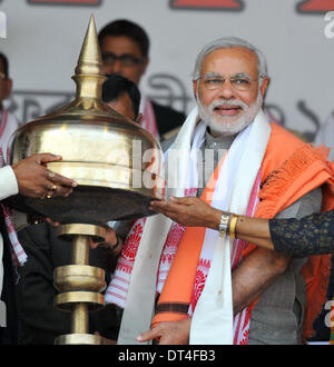 Gauhati, Inde. Feb 8, 2014. Candidat au poste de Premier Ministre d'opposition de l'Inde Bhratiya Janata Party BJP Narendra Modi pose pour des photos avec un souvenir lors d'un rassemblement public à Gauhati, Inde, le 8 février 2014. Les élections générales en Inde est prévue pour cette année, qui sera en mesure de produire un nouveau premier ministre en remplacement de M. Manmohan Singh, qui a gouverné le pays d'Asie du sud pendant 10 ans. Credit : Stringer/Xinhua/Alamy Live News Banque D'Images