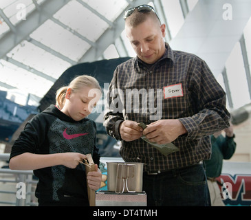 Le sergent d'artillerie. Trevor Paradis fiscaux et sa fille prendre part dans le Musée National de la Marine Corps Second Annual MRE Cook off en combinant des rations alimentaires préemballés service émis membres de créer le meilleur repas dégustation 1 Février, 2014 dans le triangle, VA. L'inculcation des pré-emballés ou les repas prêts à manger sont connus pour leur capacité à fournir la nutrition et la saveur pas. Banque D'Images