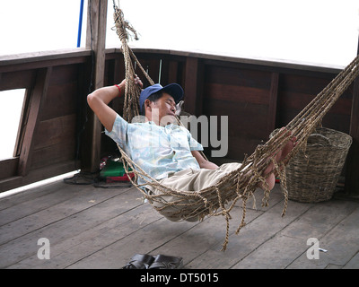 L'homme en hamac sur bateau endormi au Cambodge Banque D'Images