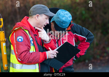 Llangynidr, Powys, Wales, UK. 9 février 2014. Les membres de l'équipe de sauvetage Brecon Mountain à la salle des fêtes centre d'opérations. Un canoéiste a disparu aujourd'hui vers midi lorsqu'il n'a pas réussi à revenir après le canoë avec un petit groupe de canoéistes sur la rivière Usk près de Llangynidr au Pays de Galles. Credit : Graham M. Lawrence/Alamy Live News. Banque D'Images