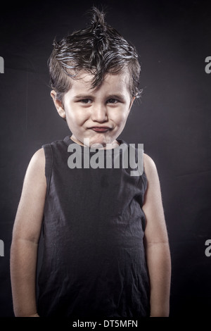 Mignon, enfant robe cache-culbuteurs et des expressions drôles crested Banque D'Images