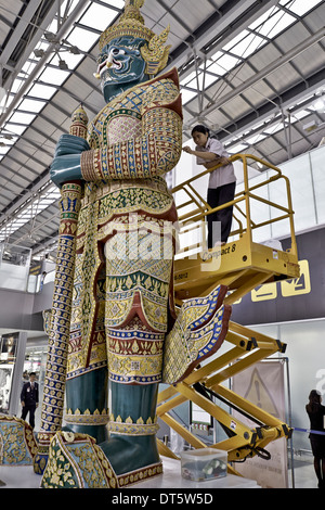 Nettoyage intérieur de la grande statue de gardien Yaksha à l'aéroport de Suvarnabhumi Bangkok Thaïlande S. E. Asie Banque D'Images