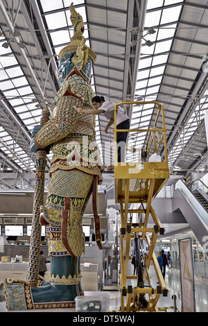 Nettoyage intérieur de la grande statue de gardien Yaksha à l'aéroport de Suvarnabhumi Bangkok Thaïlande S. E. Asie Banque D'Images