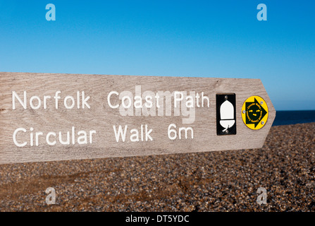 Un panneau pour le Norfolk Coast Path pointant vers la droite ou vers l'est le long de la plage de galets au nord de Salthouse Norfolk. Banque D'Images