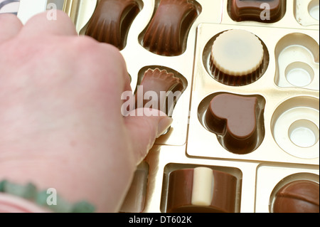 Aider la femme elle-même à un chocolat d'une boîte de chocolats Banque D'Images