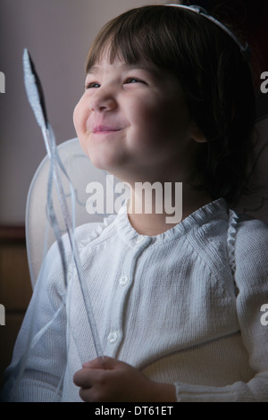 Happy female toddler avec baguette, habillés en fairy wings Banque D'Images