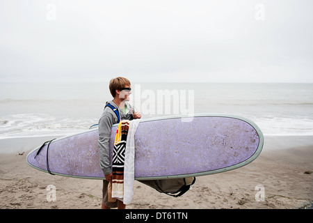 Young male surfer sur la plage de Misty, Bolinas, California, USA Banque D'Images