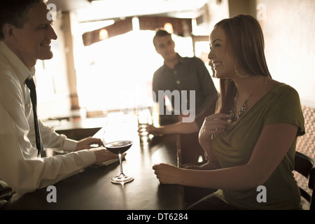 Barman de flirter avec jeune femme en bar à vin Banque D'Images