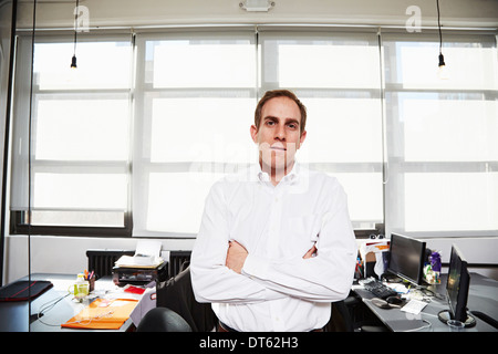 Mid adult man wearing white shirt in office Banque D'Images