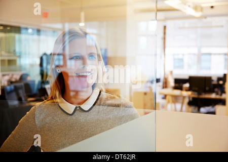 Voir à travers le verre de female office worker Banque D'Images