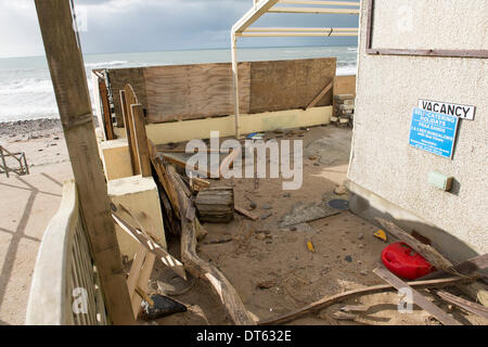 Praa Sands, Cornwall, UK. 10 fév, 2014. Les débris de la tempête a déposé au café de la plage à Praa Sands Beach Cornwall. Une grande partie du sable sur la plage a disparu, avec d'énormes rochers déposés maintenant il y a la place. Une série de tempêtes d'hiver a conduit à des vents forts et des vagues énormes qui ont causé de lourds dommages à travers le sud-ouest. Credit : Bob Sharples/Alamy Live News Banque D'Images