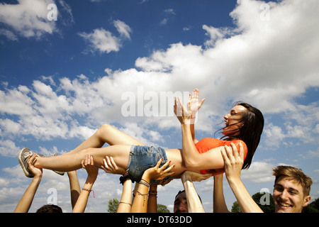 Amis Cropped shot of hands holding up young woman Banque D'Images