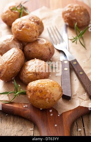 Pommes de terre au four sur planche à découper Banque D'Images