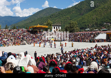 Le Bhoutan, l'Asie du Sud, Thimpu Dzong, danseurs dans la cour en festival avec la foule de gens dans les peuplements à regarder. Banque D'Images