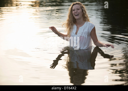 Teenage girl enjoying river dans la soirée Banque D'Images