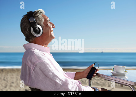 Man écouter de la musique avec des écouteurs on beach Banque D'Images