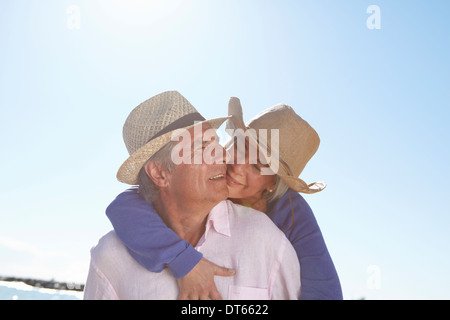 Couple portant des chapeaux de paille sur la plage Banque D'Images