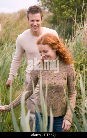 Couple strolling on grassy field Banque D'Images