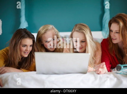 Quatre teenage girls looking at laptop dans la chambre Banque D'Images