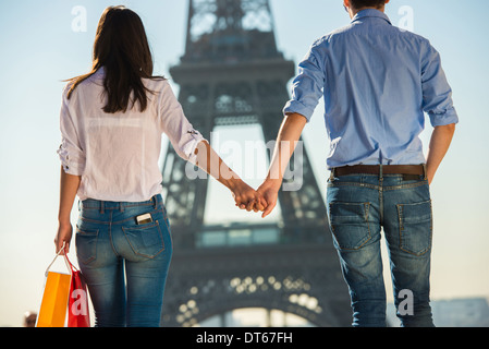 Jeune couple strolling en face de la Tour Eiffel, Paris, France Banque D'Images