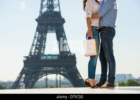 Young couple embracing in front of Eiffel Tower, Paris, France Banque D'Images