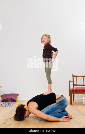 Studio shot of fille debout sur haut de père Banque D'Images