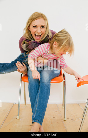 Studio Portrait of mother holding up jeune fille Banque D'Images