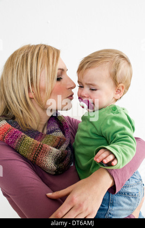 Studio portrait de mère essayant de calmer bébé fille Banque D'Images