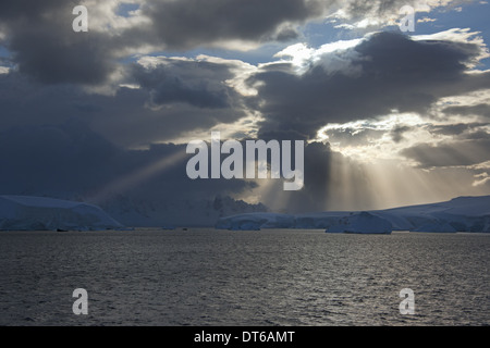 Bien briser les nuages de tempête de frapper les icebergs le long de la côte ouest de la péninsule antarctique. Banque D'Images