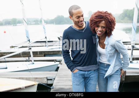 Jeune couple on jetty laughing Banque D'Images