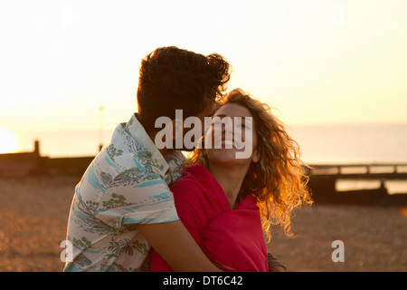 Jeune couple wrapped in towel on beach Banque D'Images