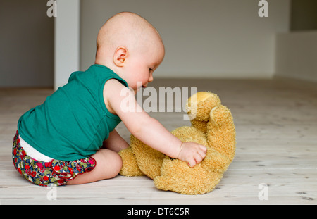 Baby Girl Playing with teddy bear sur marbre Banque D'Images