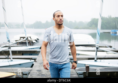 Jeune homme sur jetty en marina Banque D'Images